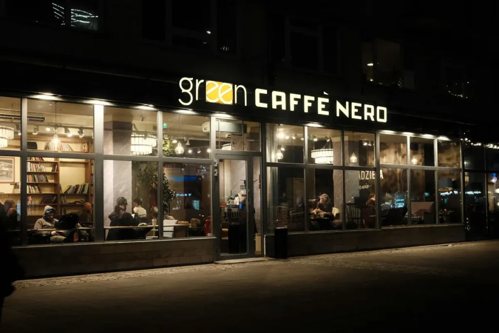 Devanture éclairée d'un café commerce local la nuit